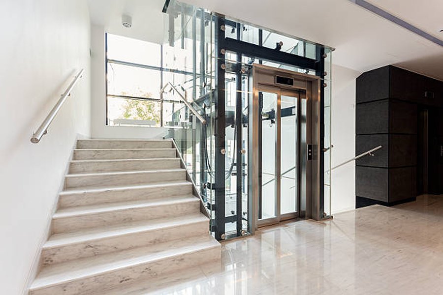 A glass-sided home lift beside the stair.